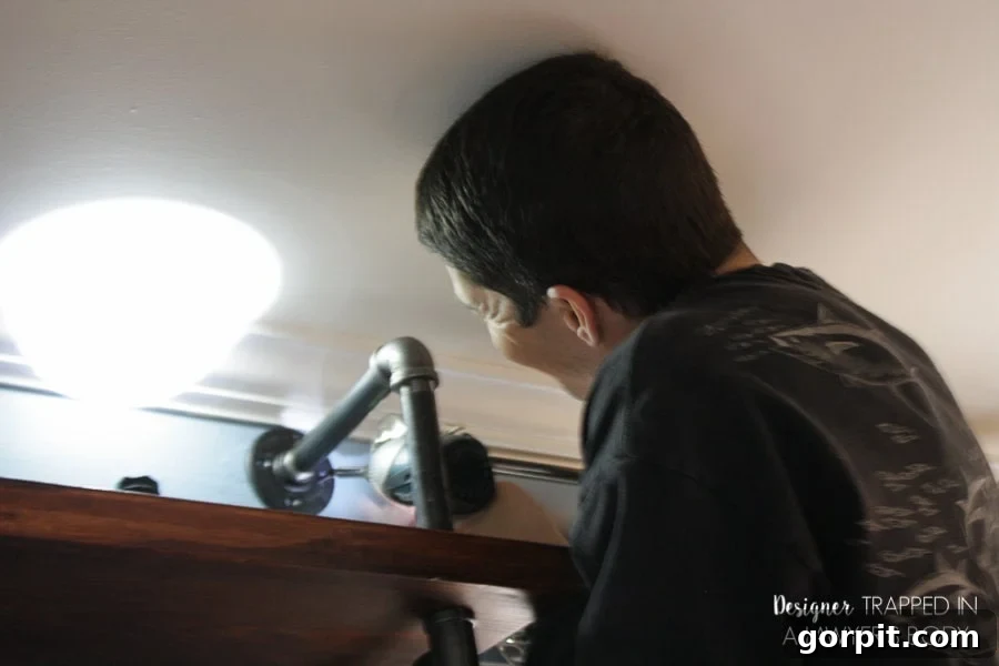 Securing the top of DIY pipe shelves to the wall with a flange