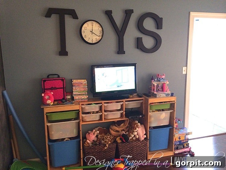 Cluttered playroom before DIY pipe shelves and desks