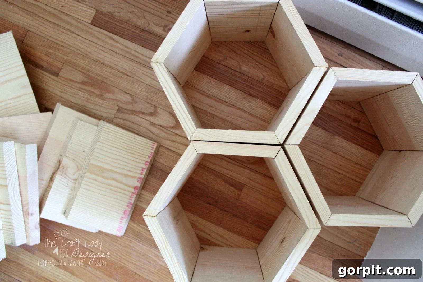 Honeycomb Shoe Rack DIY 11 An overhead view of assembled hexagonal shoe cubbies put together with nails and wood glue. Additional raw wood pieces are to the left.