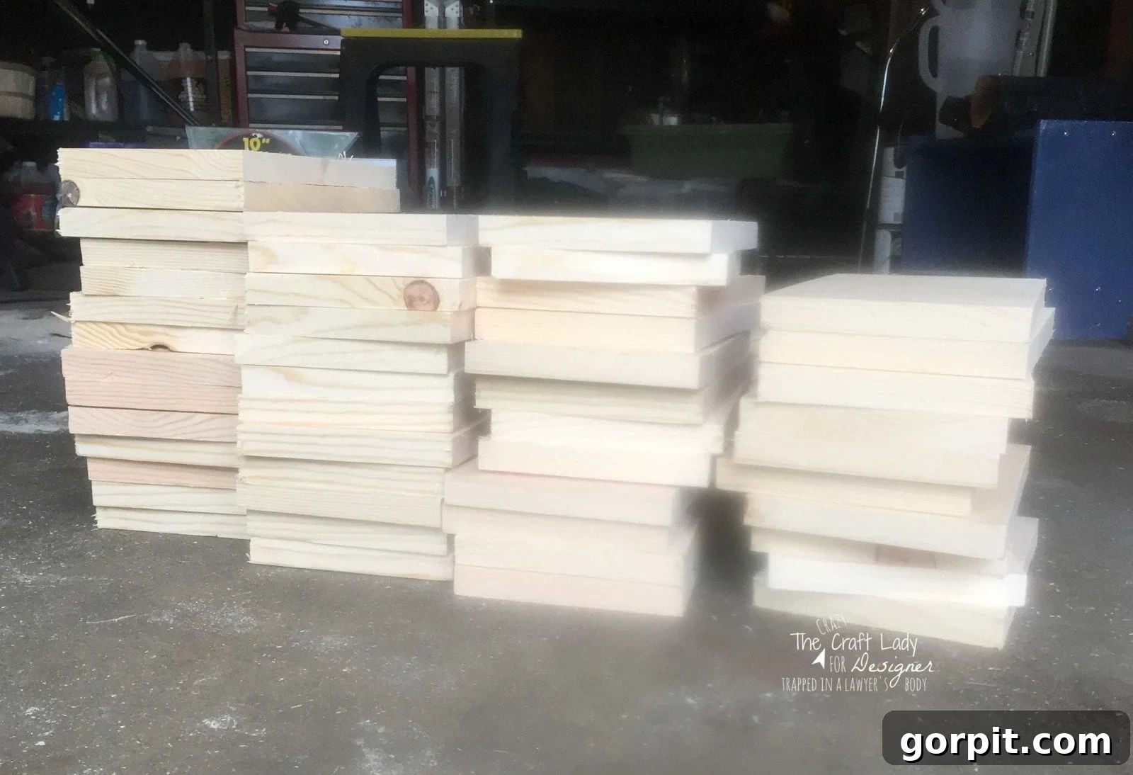 Honeycomb Shoe Rack DIY 7 A picture of four stacks of square wood pieces on a garage floor, ready to be made into hexagonal pieces for a DIY shoe rack.