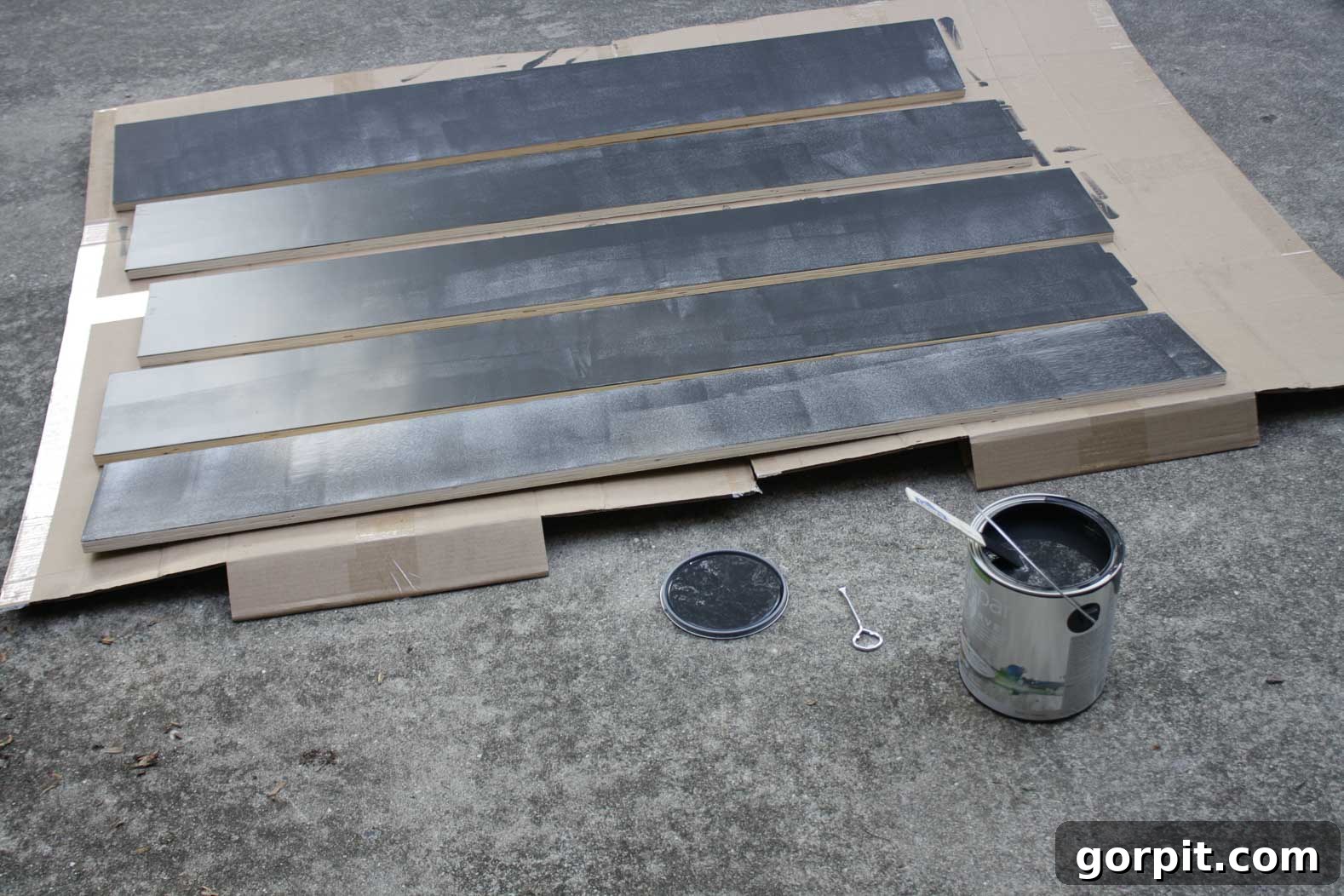 Stair risers being painted black to create a modern contrast with the new wood treads.