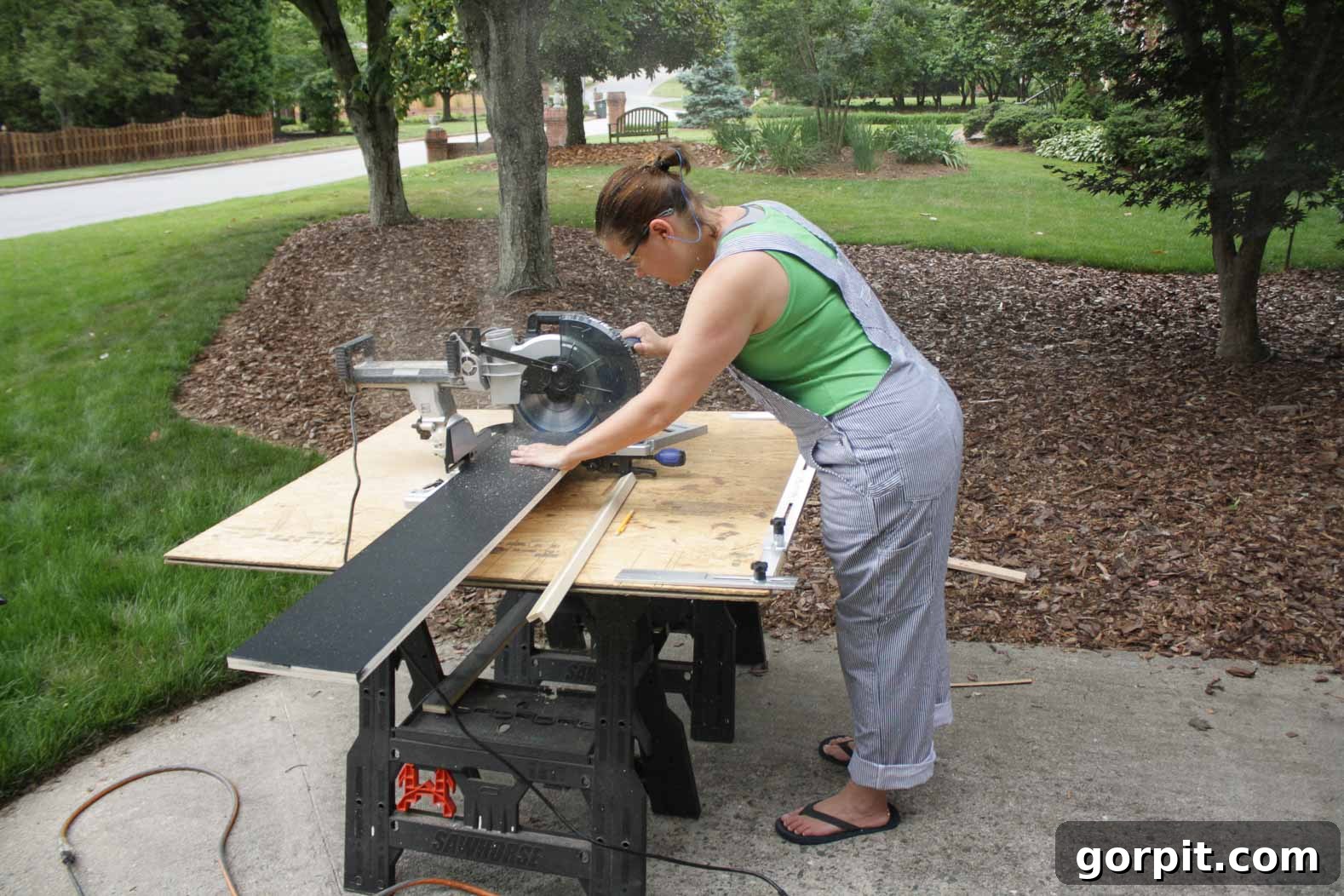 Detailed shot of a person cutting a new stair riser to precise size using a miter saw.