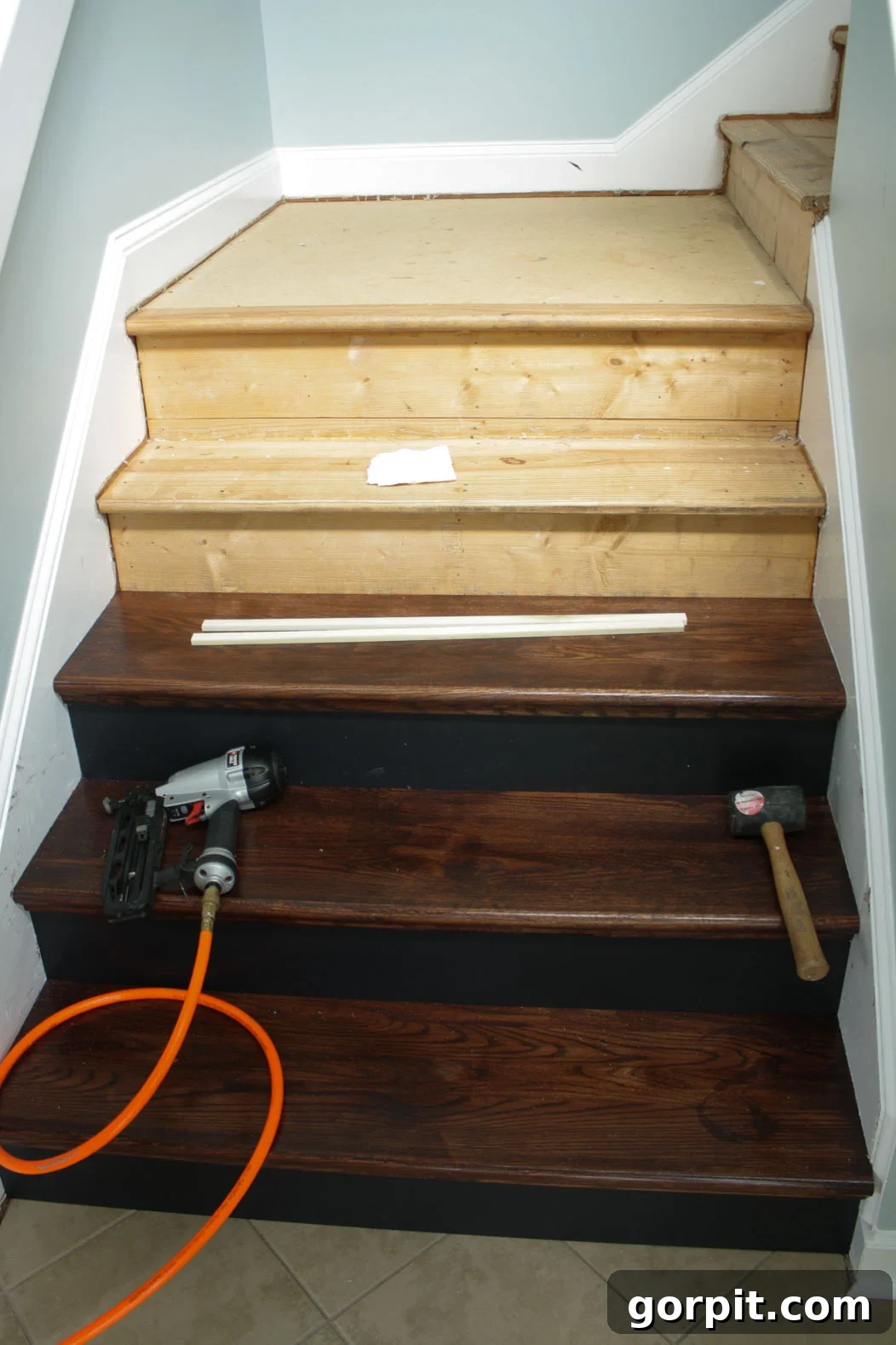 Continuous installation of new hardwood stair treads and risers, progressing up the staircase.
