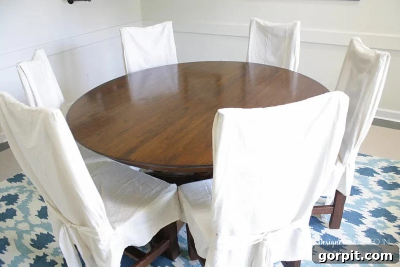 Refinished dining table with white chairs, showing a smooth, even wood tone.