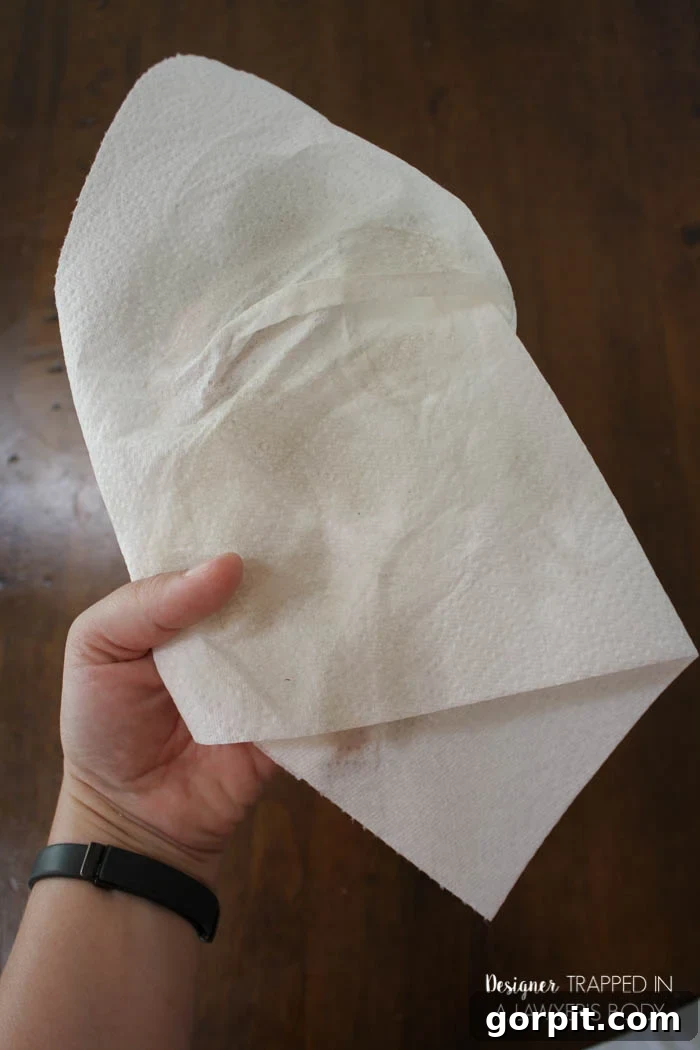 Dirty paper towel after cleaning table with wax wash remover, showing accumulated grime.