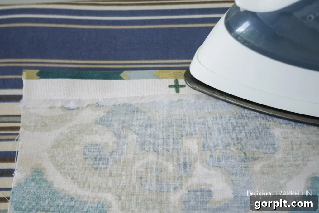 Easy DIY Curtains 5 Folding and pressing the first hem for DIY curtains. A detailed step in creating neat, finished edges for your custom panels.