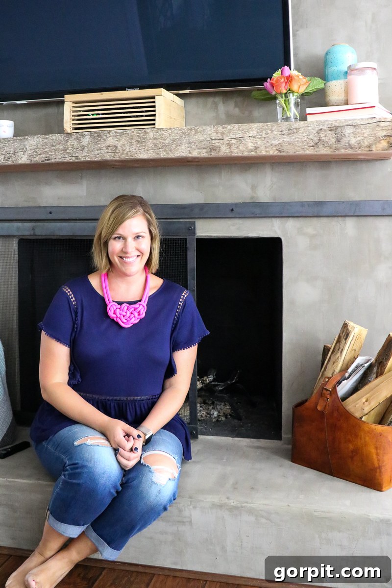 A close-up view of the DIY concrete fireplace featuring a custom-built metal sliding barn door screen.
