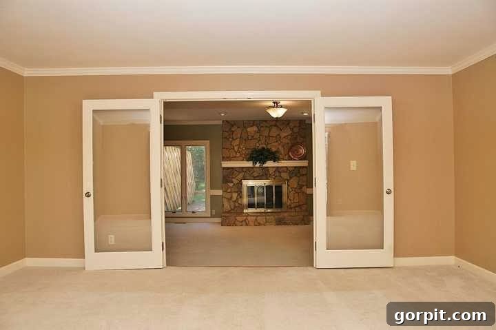 Before image of an outdated living room with an old stone fireplace.