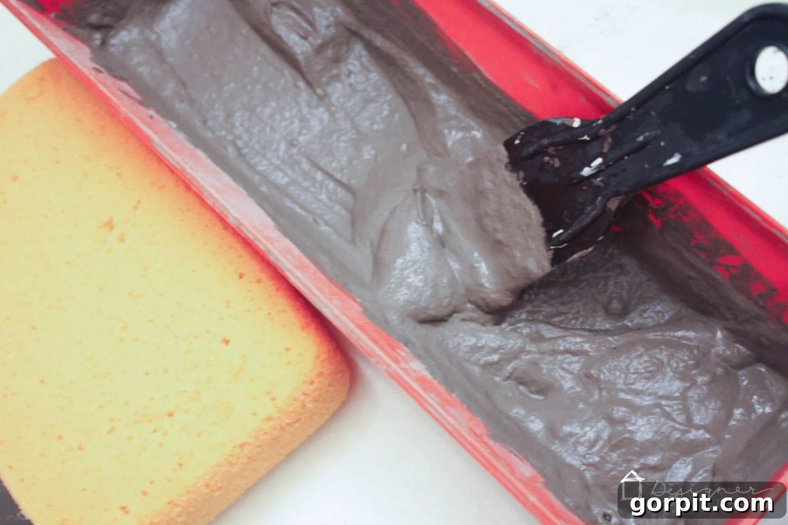 Close-up of Ardex Feather Finish concrete mixture, showing the ideal thin pancake batter consistency in a bucket.