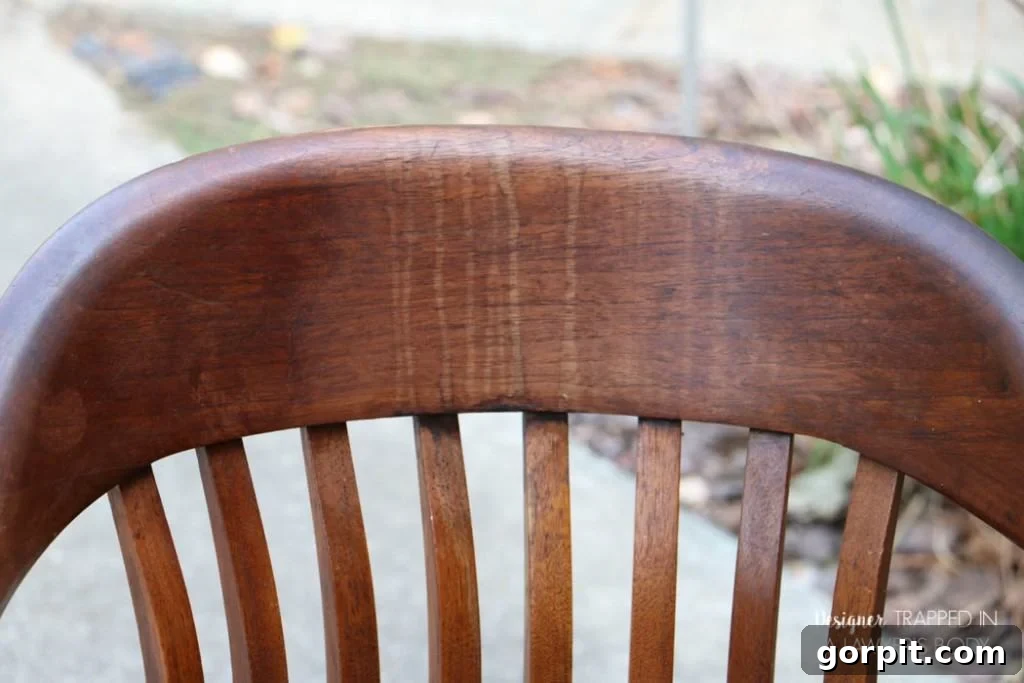 Revitalize Your Wood Chairs Effortlessly 20 Before photo of Chair #2, close-up, highlighting the damage